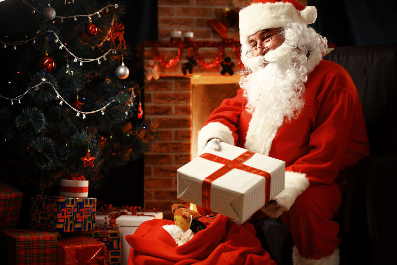 圣诞老人坐在屋顶上拿着礼物