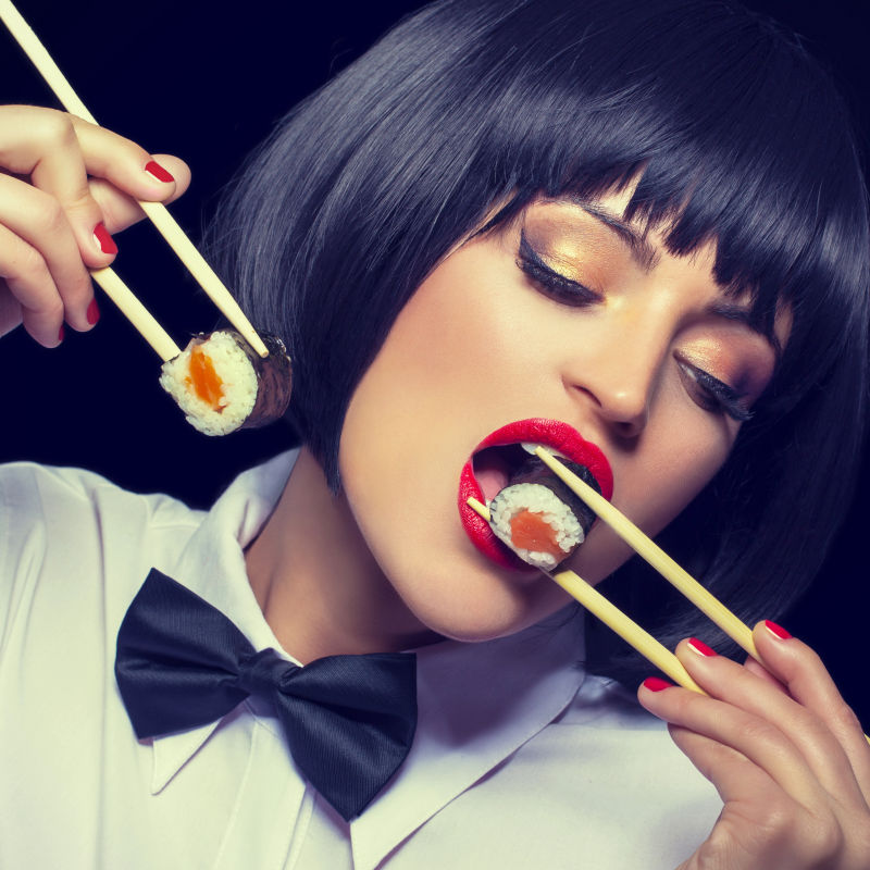 夹着两个寿司的美女