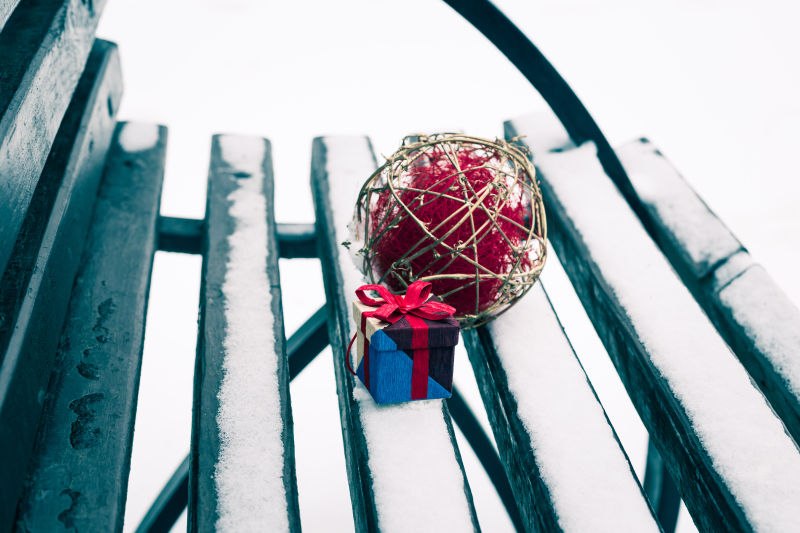 满是雪花的木椅子上放着礼物盒