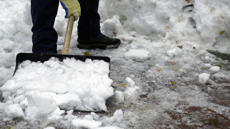 男人打扫院子里的积雪