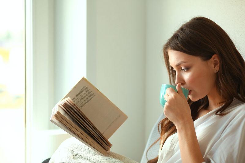 美女拿着书喝着咖啡