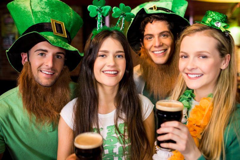 四个穿着爱尔兰风格的年轻人在喝啤酒
