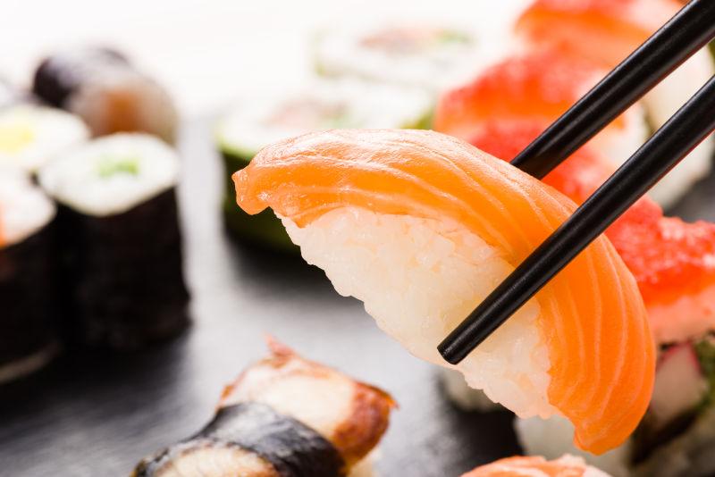 筷子夹住寿司特写