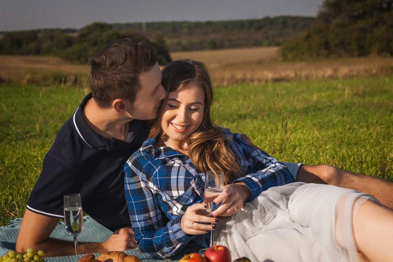 户外草地上野餐的年轻情侣