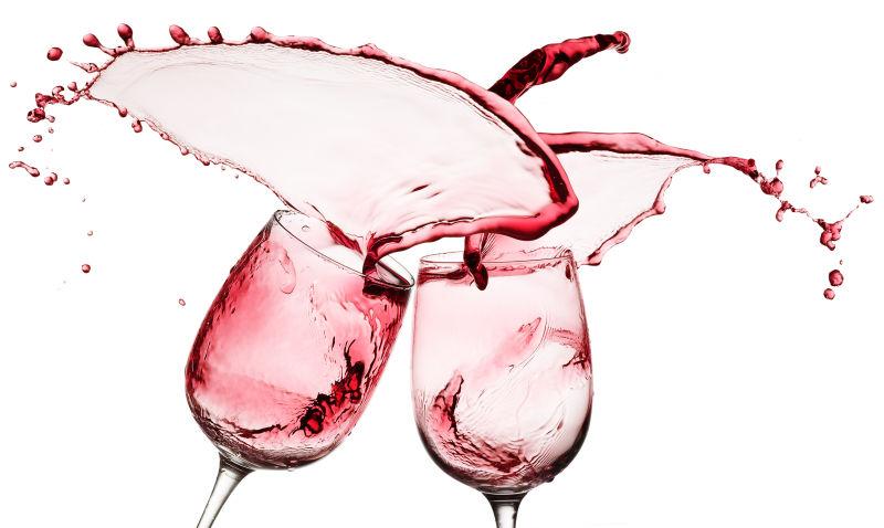 白色背景上两个玻璃杯里的飞溅的红葡萄酒