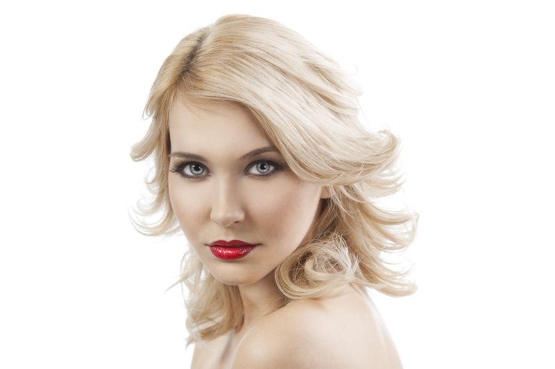 白色背景前的金色短发年轻美女