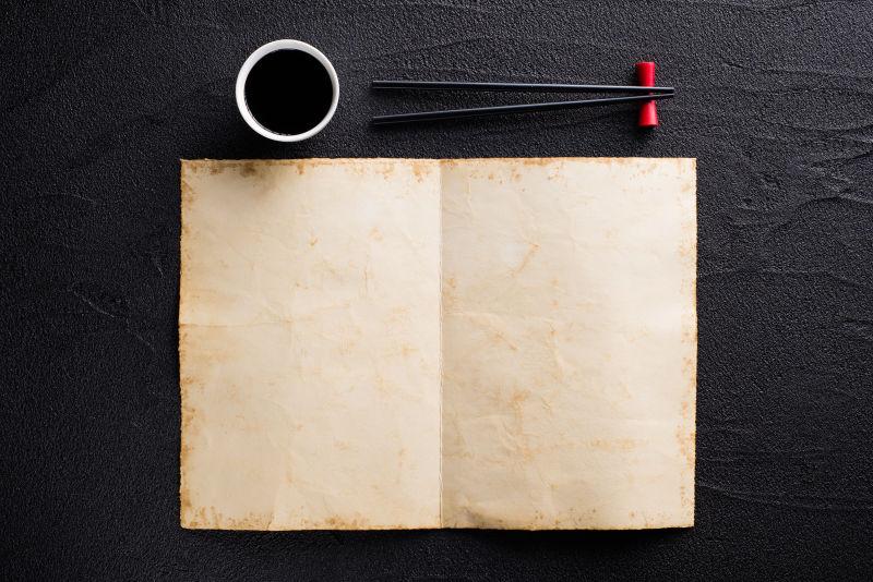 黑色桌面上的空白菜单和餐具