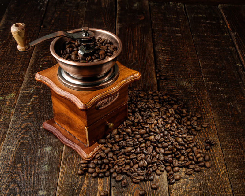 木板上的咖啡豆与磨豆机