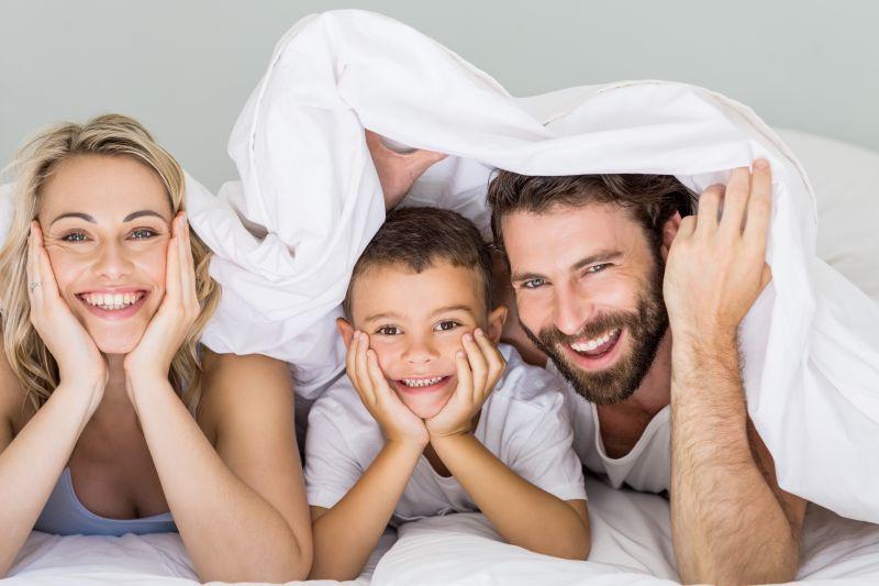 微笑的一家人在床上