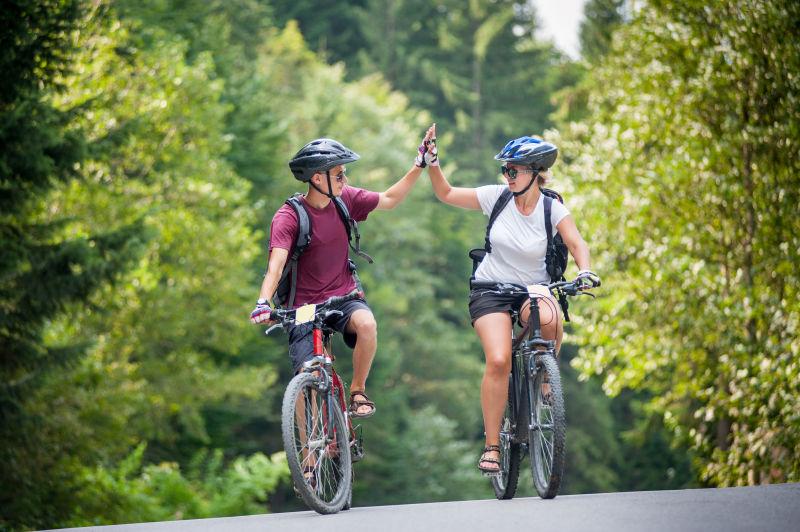 在油柏路上骑自行车击掌的人