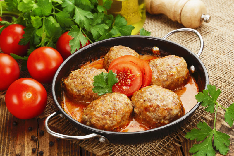 木质板上的西红柿和铁板里的美事