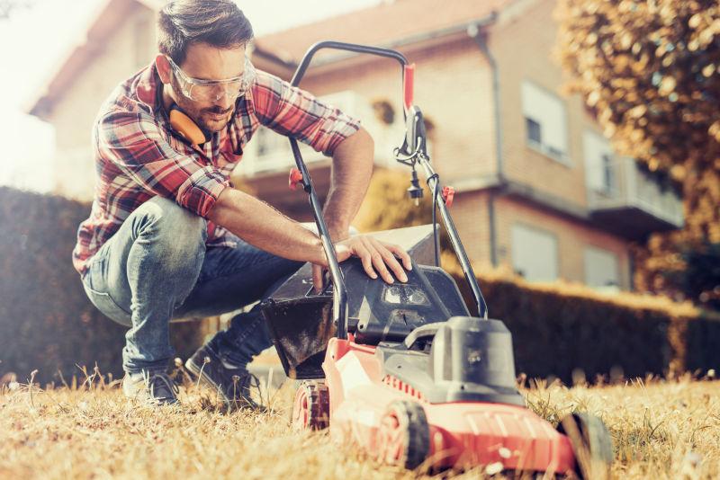 男人在院子里割草中