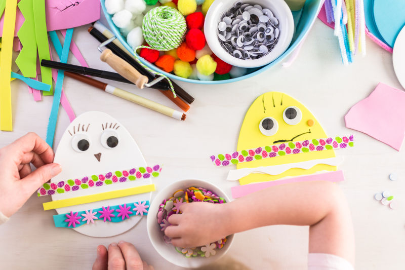 桌面上正在制作复活节彩蛋饰品的孩子