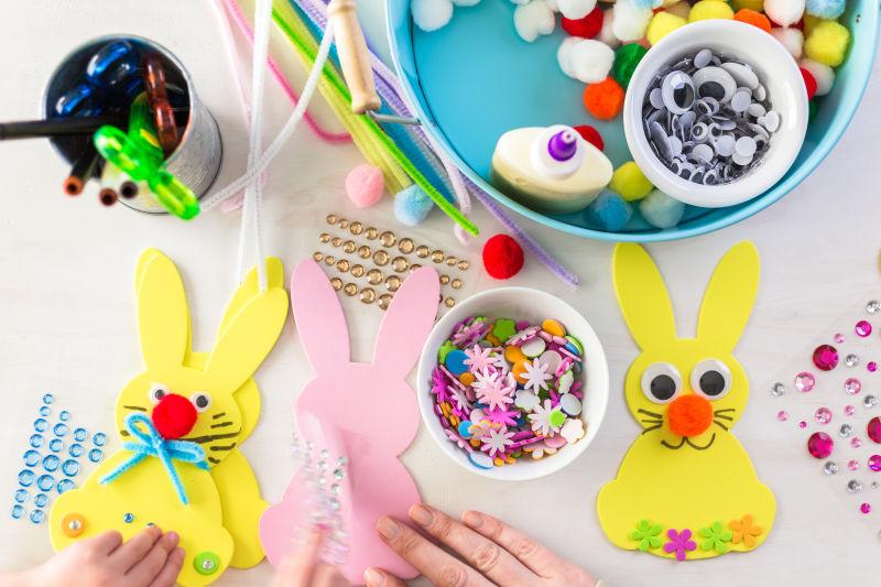 桌子上正在制作可爱的复活节兔子饰品的人