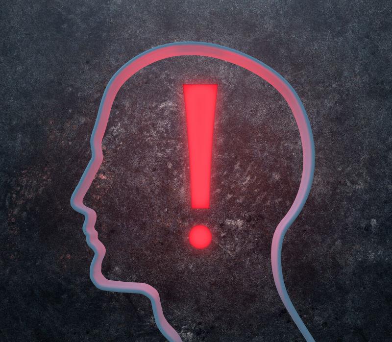 黑色背景下的男性头骨上的感叹号