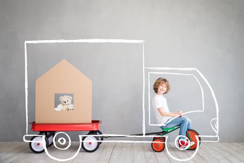 儿童开着汽车搬家理念