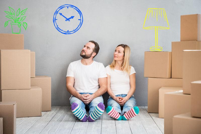 坐在木质地板上的年轻夫妇