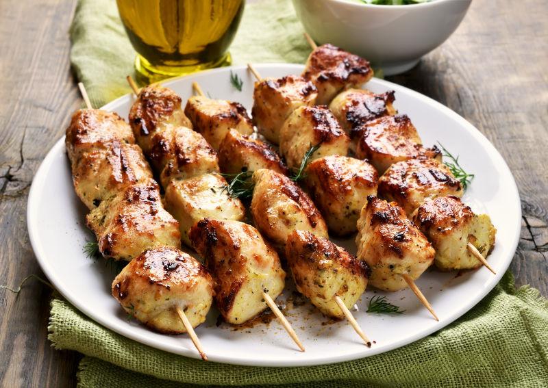 桌子上盘子里的烤鸡肉串