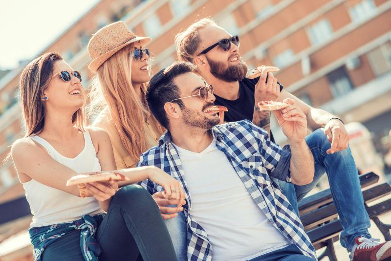 户外享受披萨的四个好朋友