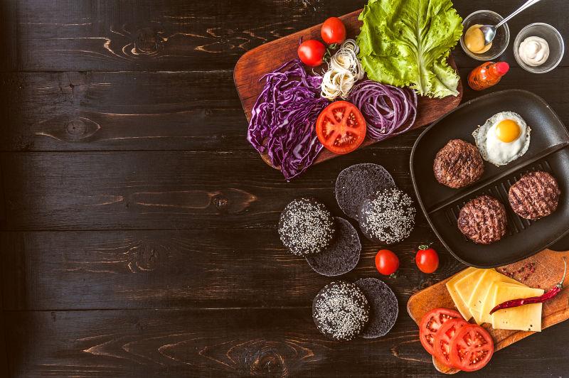 盘子里的黑色汉堡包和配料