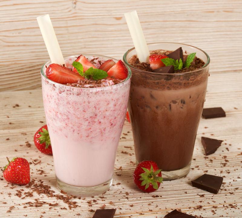 木制背景下的巧克力和草莓奶昔