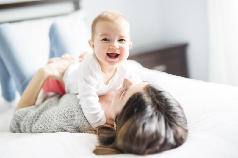抱着刚出生婴儿的妈妈躺在床上