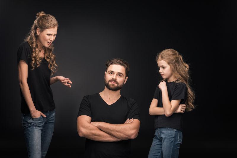 母女和父亲抱着黑色的手臂坐着