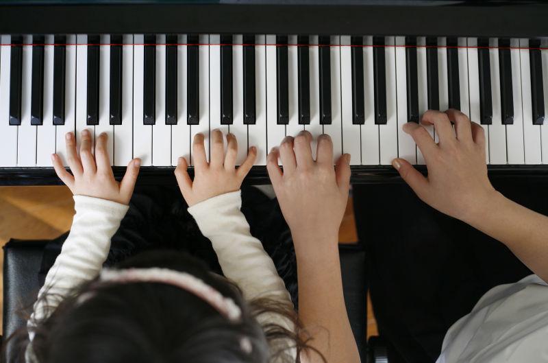 钢琴教室中正在练习弹钢琴的小孩