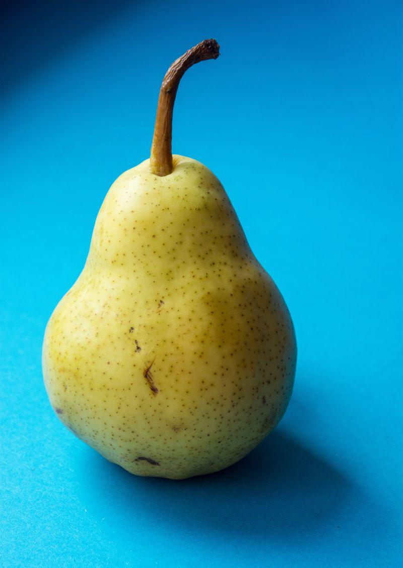 蓝色桌上的黄色梨子