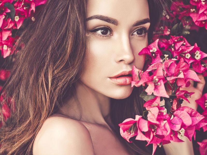 被红色鲜花包围的露着肩膀的美女