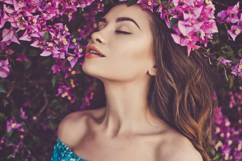 被紫粉色鲜花包围的十分享受的美女