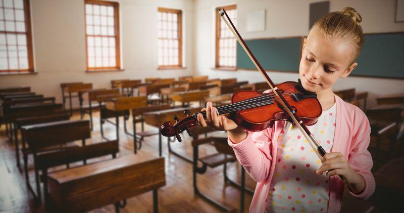 小女孩在空无一人的教室里拉小提琴