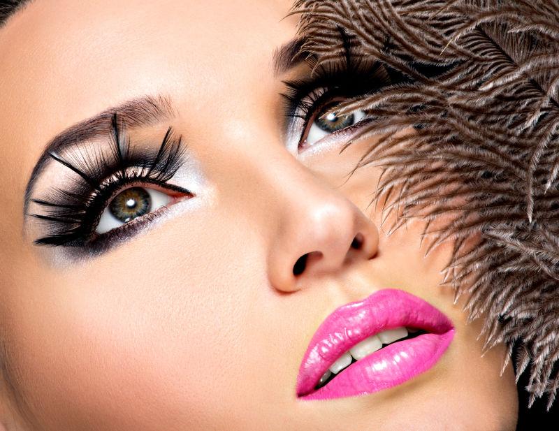 羽毛装饰背景中时尚的美女