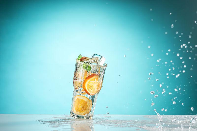 蓝色背景上的加冰柠檬水和水滴