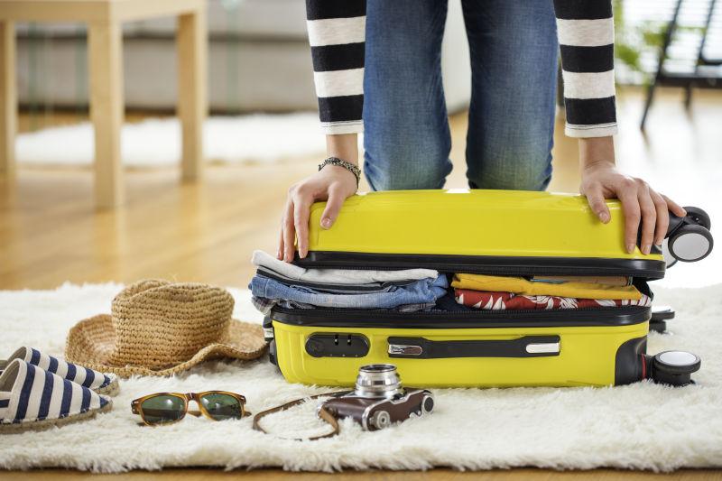 女人正在家里准备旅行箱衣服