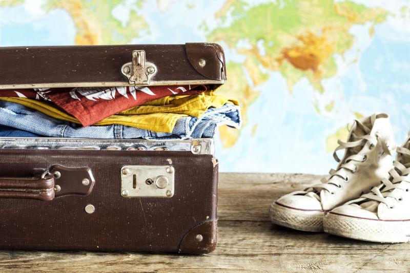 木桌子上的旅行箱和鞋子