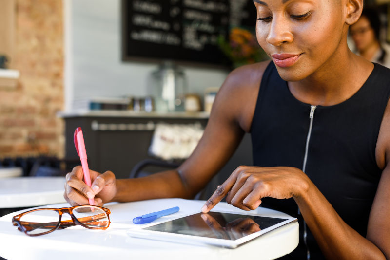非洲女商人在咖啡馆使用平板电脑办公