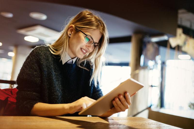 女学生在咖啡馆使用平板电脑