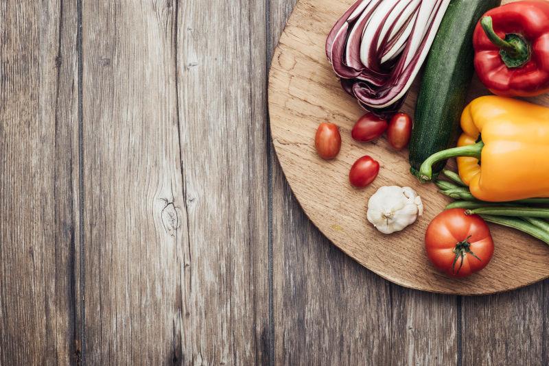 新鲜美味的蔬菜和老式的木制工作台上的砧板