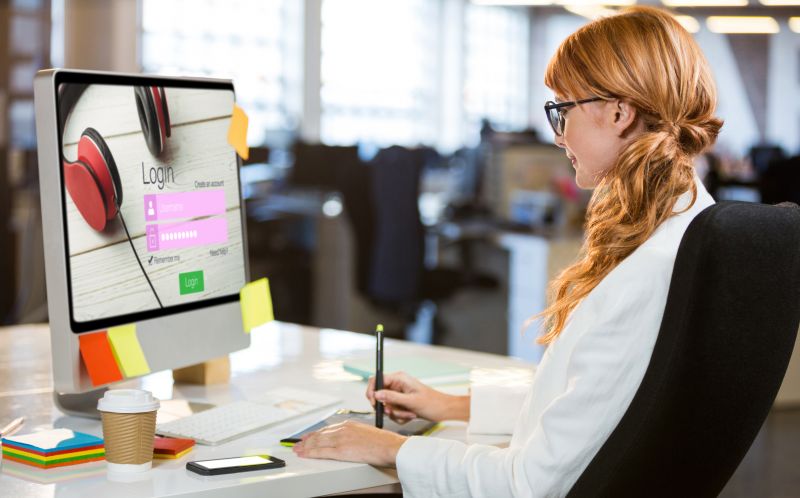 女人坐在屏幕显示网站登陆页面的电脑前