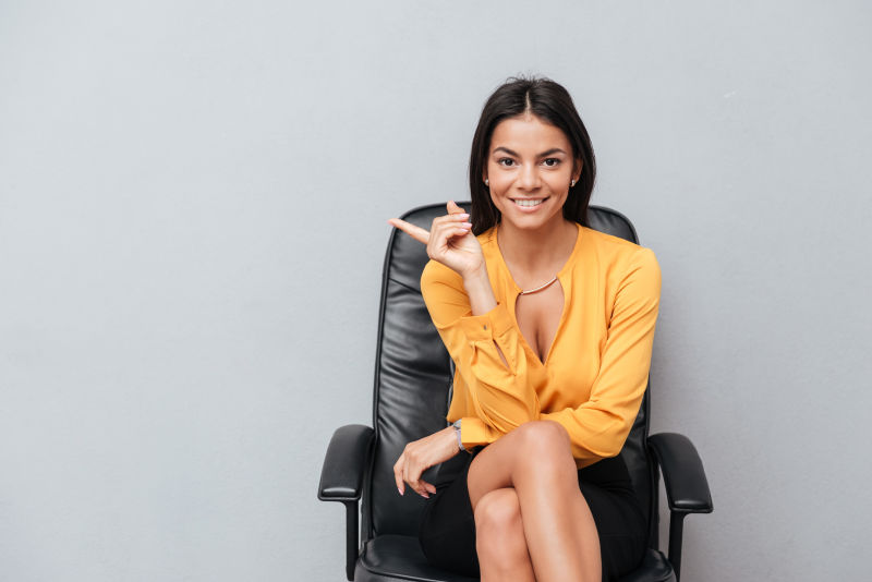 一个笑容满面的女商人坐在椅子上