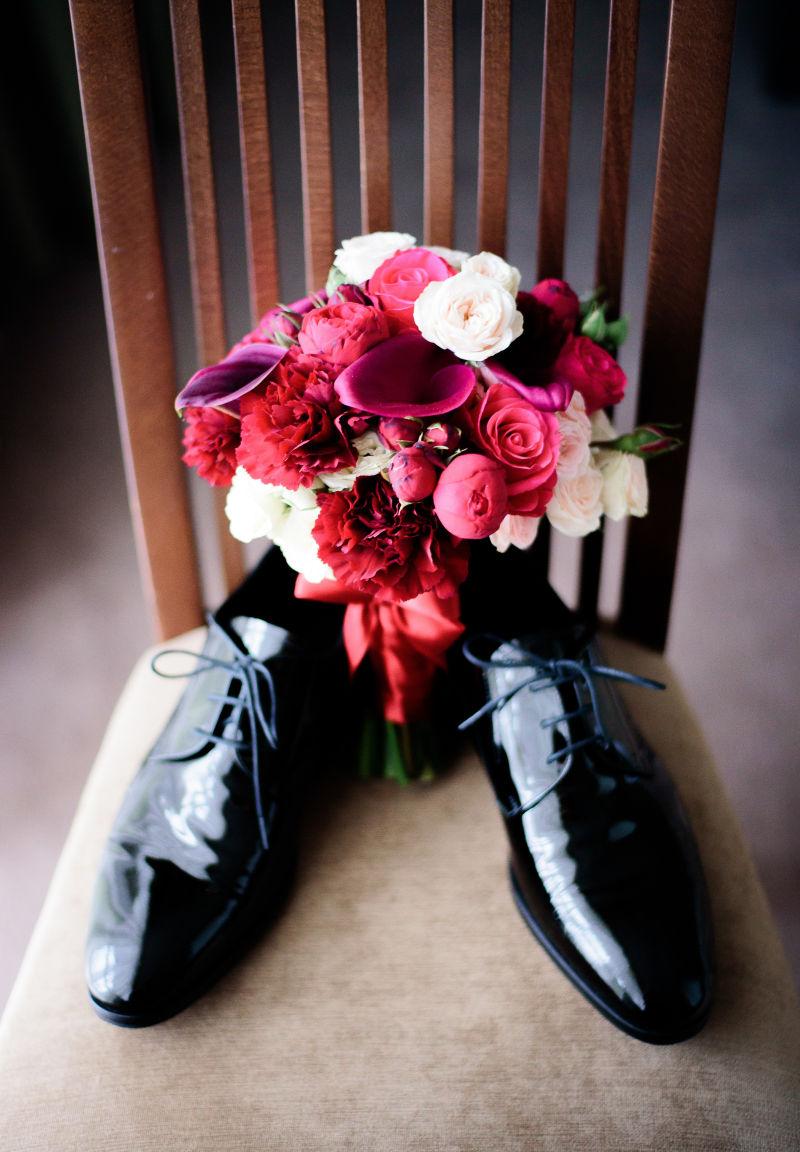 红花的手捧花放在皮鞋中间