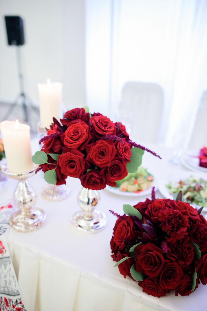 白色的餐桌上摆着一束红玫瑰