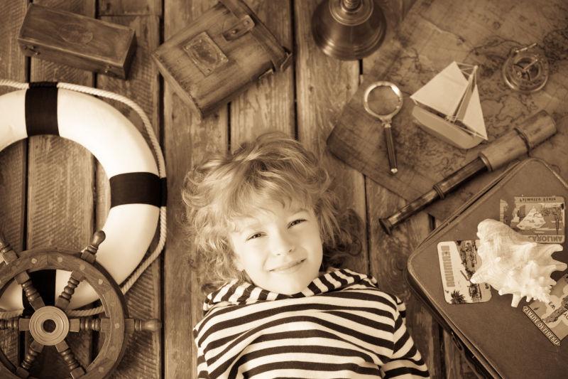 男孩躺在放着航海用品的地板上