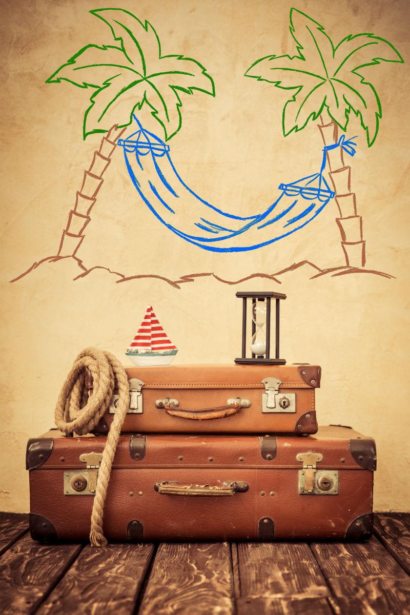 椰子吊床壁画下的旅行皮箱