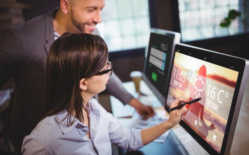 男女同事之间看着电脑上的天气预报