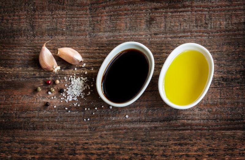 木桌上的橄榄油香醋大蒜盐和胡椒汁