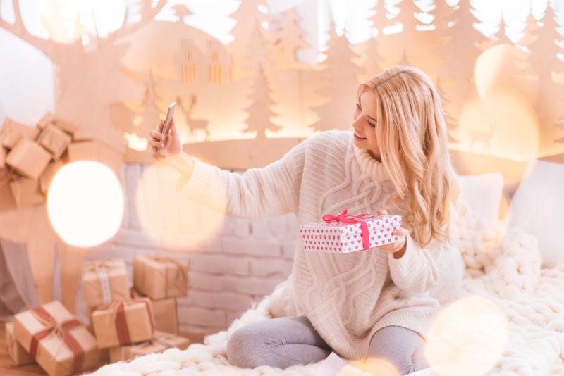 年轻女人拿着礼物盒在自拍