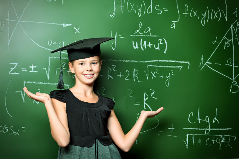 教室里面带微笑戴学术帽的女学生