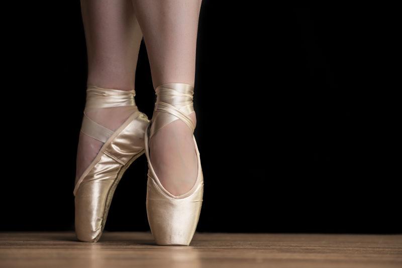 芭蕾舞女郎穿着白色的芭蕾舞鞋和尖鞋